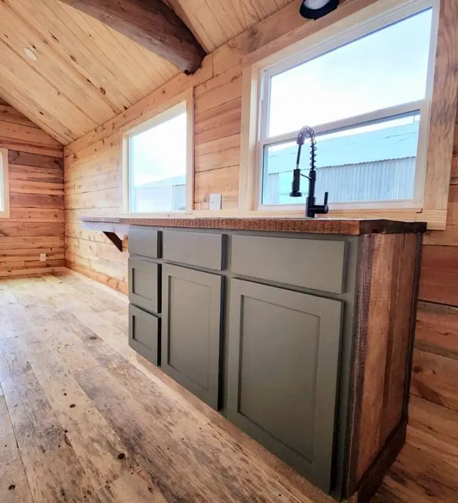 Kitchen base cabinets under a window in a log cabin