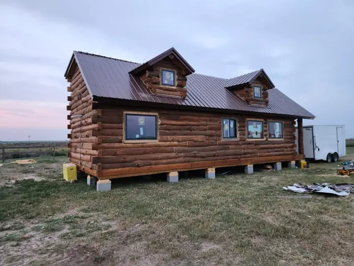 Large solid-log cabin with roof dormers, delivered on site