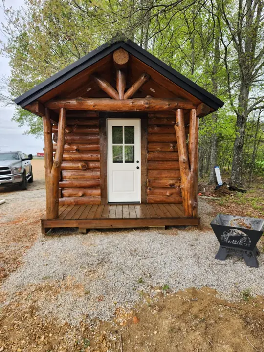 Solid-log cabin front with gable trim and entry door